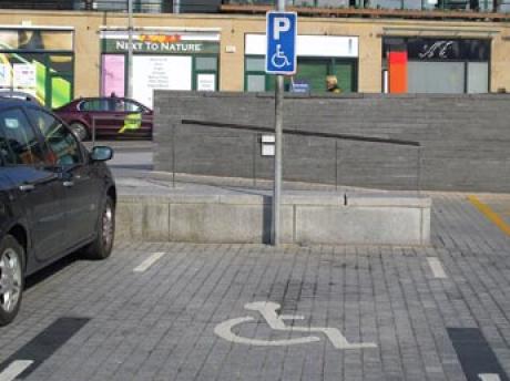 accessible parking bay showing markings and blue sign with accessible logo