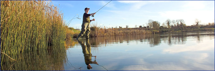 Photograph of man fishing at the edge of water