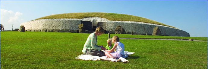 Family having picnic on the grass in front of Newgrange monument