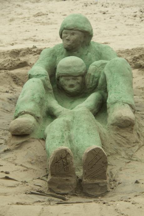 National Sandcastle and Sand Sculpturing Festival - photo of sculpture of two figures wearing helmets sitting together one in front of the other.